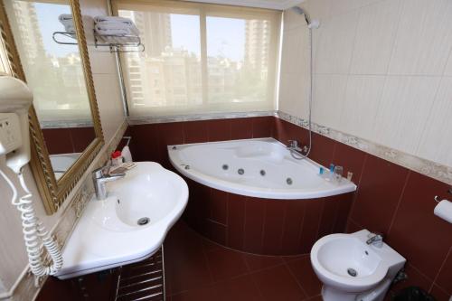 ein Badezimmer mit einer Badewanne, einem Waschbecken und einem WC in der Unterkunft Duroy Hotel By Beverly in Beirut