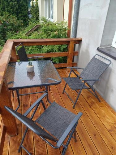 einen Tisch und zwei Stühle auf dem Balkon in der Unterkunft Apartamenty, Pokoje, Noclegi pracownicze " Skarpa" Wilkasy in Wilkasy