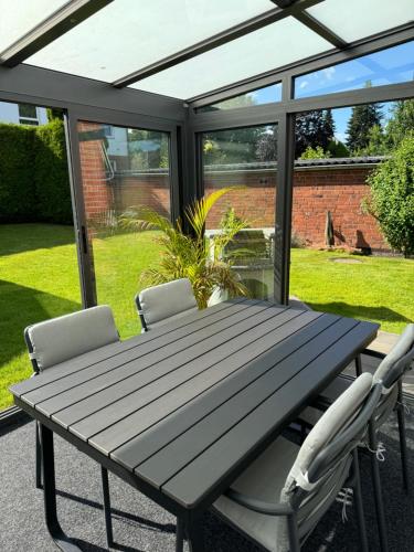 - une table de pique-nique et des chaises sur la terrasse dans l'établissement Ferienwohnung Aspelohe - Apartment 2, à Norderstedt