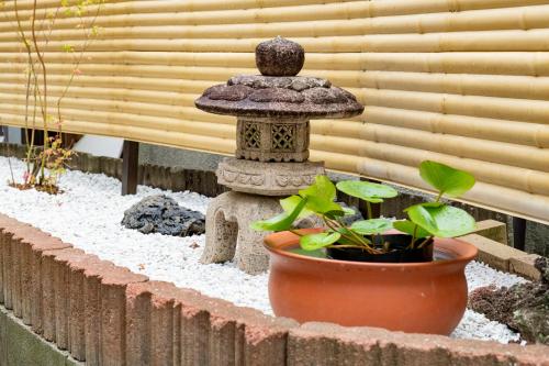 einen Garten mit Vogelbad und Pflanze in der Unterkunft 広島駅北口 古民家 Koisi 一軒家貸切り 自転車4台レンタル無料 in Hiroshima