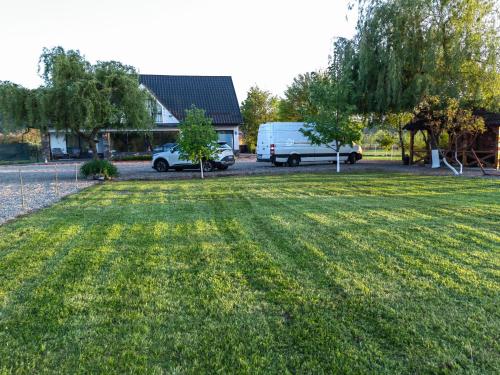 een busje geparkeerd in een tuin met een grasveld bij Casa Boila in Bîrsana