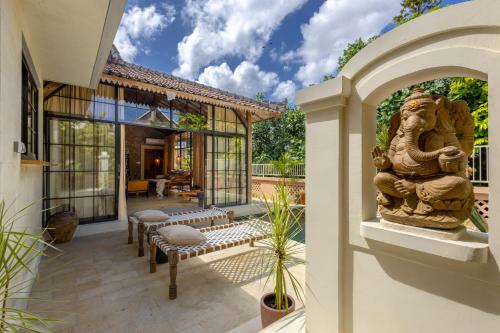 A garden outside The Pink Joglo, a cheerful 3BDR Villa W/Pool and Rice-field view.