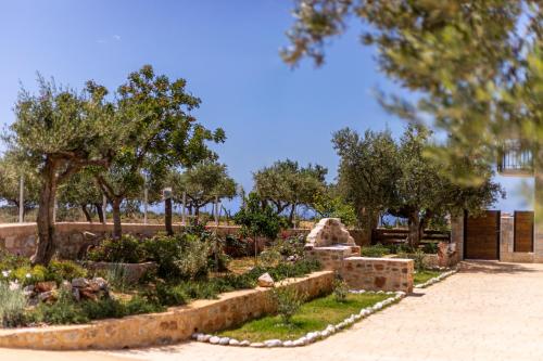 a garden with trees and flowers in a park at Lakkos Villas in Kardamili