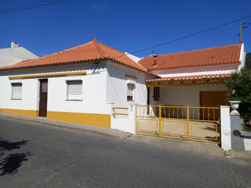 una casa blanca y amarilla con una puerta en una calle en Casa d'Avó, en Araújo