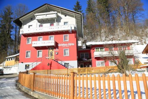 un edificio rosso con una recinzione di fronte di Gästehaus Alpina a Berchtesgaden