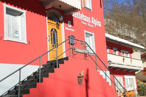 un edificio rosso con scale di fronte di Gästehaus Alpina a Berchtesgaden