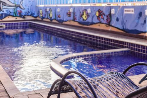 a swimming pool with a bench in front of it at HANNA San Diego Apart Hotel in Florianópolis