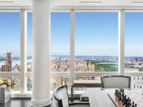 een kamer met een tafel en stoelen en grote ramen bij Stunning views of Manhattan in New York