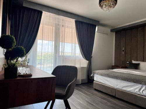 una camera con letto e scrivania con sedia di Hanul Domnesc Imperial Hotel & SPA a Călan