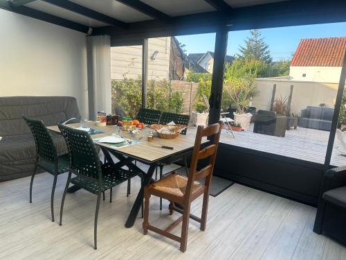 uma mesa de jantar e cadeiras com vista para um pátio em Villa les Buissonets em Berck-sur-Mer