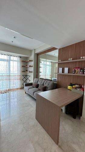 a living room with a couch and a table at Apt Puri Orchard at puri in Jakarta