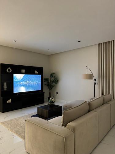 sala de estar con sofá y TV de pantalla plana en Sunrise Luxury Two Bedroom Apartment, en Al Khobar