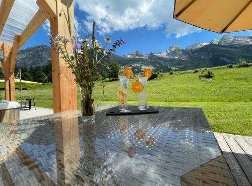 una mesa con dos vasos y una sombrilla en el patio en Chalet-Hôtel Inarpa, en La Clusaz