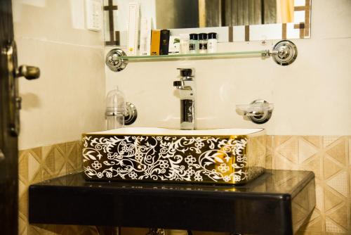 baño con lavabo blanco y negro en Sunset Heights Resort & Residencia en Islamabad