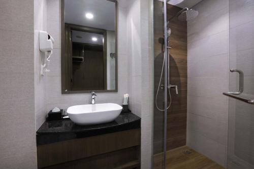 y baño con lavabo y ducha. en Harper Premier Nagoya Batam, en Nagoya