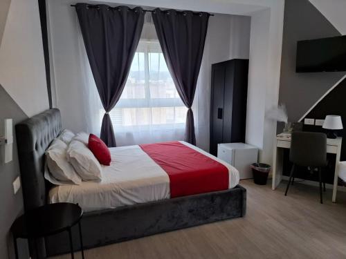 a bedroom with a bed and a desk and a window at U Baruni B&B in Messina