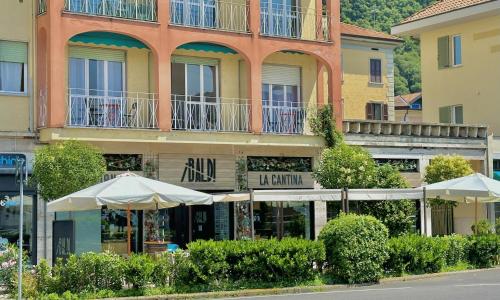 un grande edificio con ombrelloni di fronte di Locanda Da I Baldi a Laveno