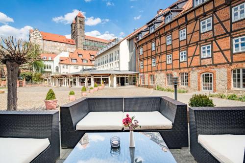 um pátio com dois sofás e uma mesa com flores em Best Western Hotel Schlossmühle Quedlinburg em Quedlinburg