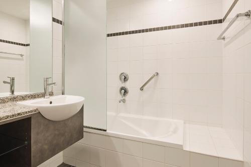 a white bathroom with a sink and a tub at Esplanade Hotel Fremantle - by Rydges in Fremantle