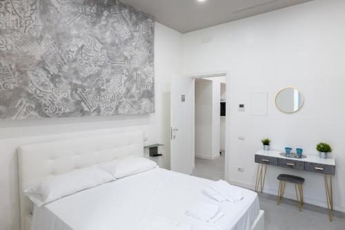 um quarto branco com uma cama branca e uma mesa em Relais Palazzo Nizza - Luxotel & Apartotel em Salerno