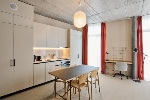 - une cuisine et une salle à manger avec une table et des chaises dans l'établissement Ariv Design Apartments Zug, à Cham