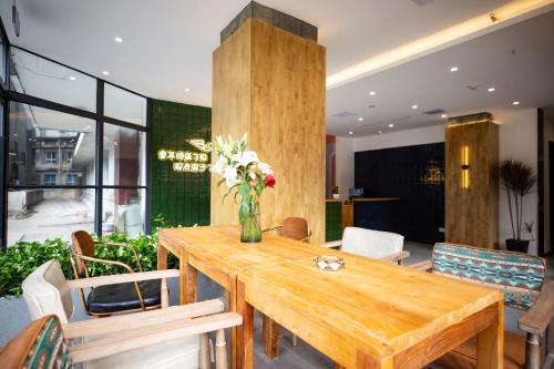 een eetkamer met een houten tafel en stoelen bij 重庆陌隅酒店 - 人民大礼堂地铁站店 in Chongqing