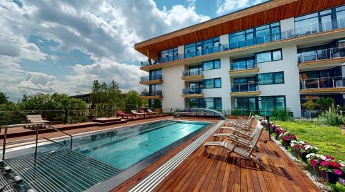 a swimming pool in front of a building at Apartmánový Hotel HREBIENOK RESORT in Vysoké Tatry