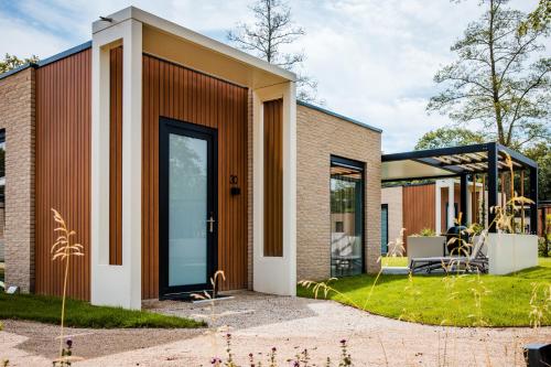 a brick house with a large glass door at Recreatiewoning 'Steenpatrijs' in Voorthuizen