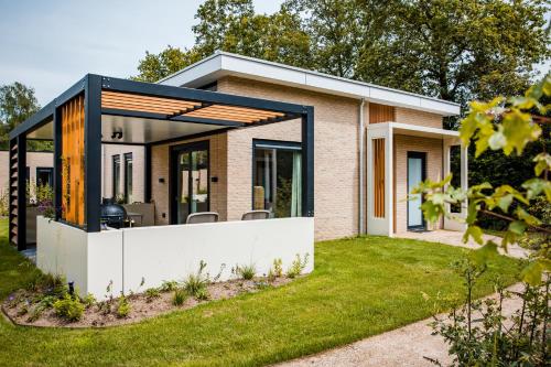 a modern house with a glass extension at Recreatiewoning 'Steenpatrijs' in Voorthuizen