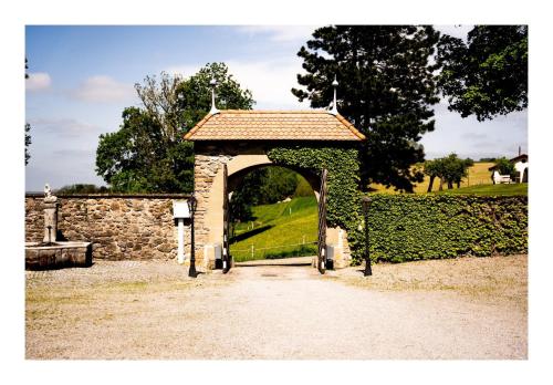 einen steinernen Torbogen mit Zugang zu einem Garten in der Unterkunft B&B Château la Grande Riedera 