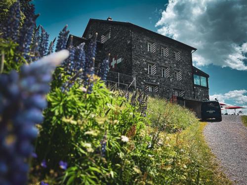 Ein Gebäude mit einem Blumenstrauß davor. in der Unterkunft Maison de Montagne de Bretaye accès par le train arrêt Bouquetin in Villars-sur-Ollon