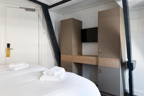 um quarto com 2 camas e toalhas brancas em Anegang Boutique Hotel em Haarlem