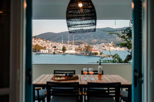 a table with a bottle of wine and a view of the water at Nikis Village in Poros