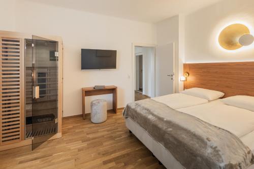 um quarto com uma cama e uma televisão de ecrã plano em das zellersee em Zell am See