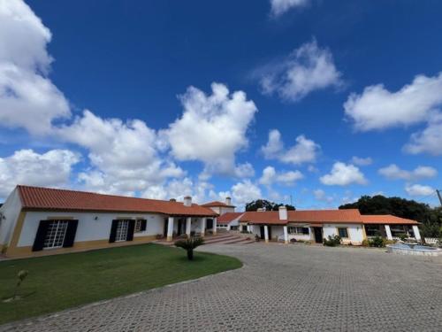 um grande edifício branco com um céu azul em Quinta do Marmeleiro em Santiago do Cacém