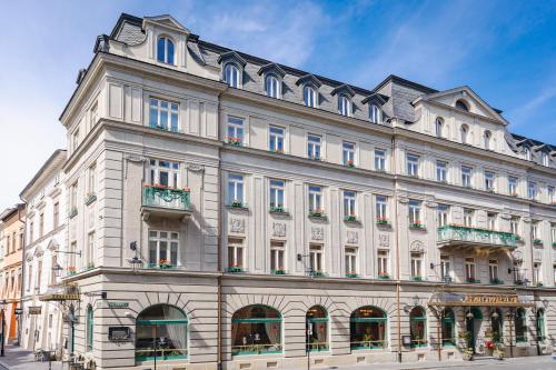 a large white building on the corner of a street at Hotel H15 Francuski Old Town - Destigo Hotels in Kraków