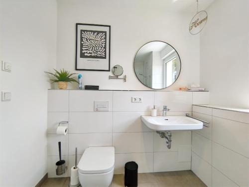 bagno bianco con servizi igienici e lavandino di CityVibe Apartment für bis zu 4 a Erlangen