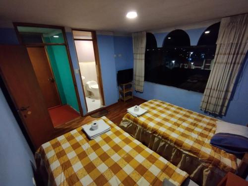 a hotel room with two beds and a window at Inti Ut'ha in Puno