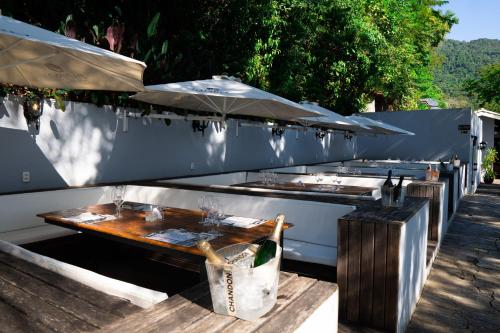 - un barbecue extérieur avec une table et des parasols dans l'établissement Pousada Papiro Boutique, à Abraão