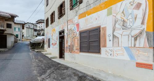 an alley with graffiti on the side of a building at Lioda Roccia in Masariè