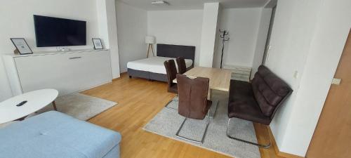 ein Wohnzimmer mit einem Sofa und einem Tisch mit Stühlen in der Unterkunft Ferienwohnung Dado in Eisenstadt