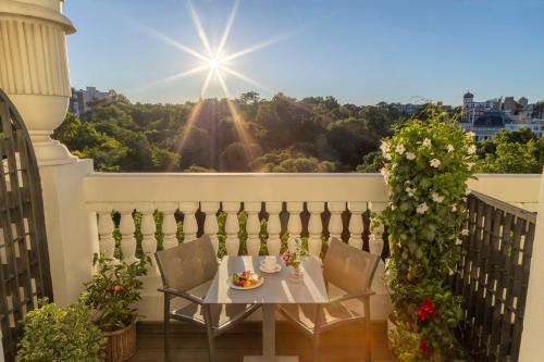 uma mesa e cadeiras numa varanda com sol em NH Madrid Nacional em Madrid