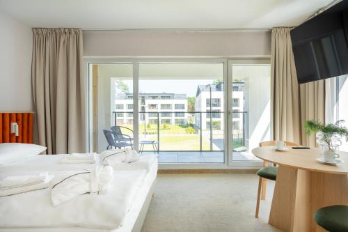 a hotel room with a bed and a large window at Sea Shell Apartments Łukęcin in Łukęcin