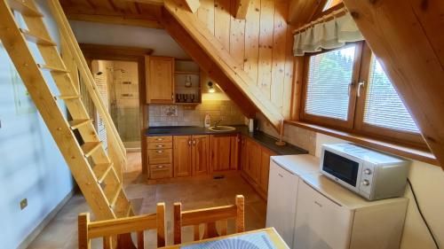 une cuisine avec des placards en bois et un escalier dans une cabine dans l'établissement Roubenka Poldovka, à Volfířov