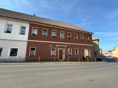 ein braunes und weißes Gebäude an der Straßenseite in der Unterkunft Apartmán Kostomlaty pod Milešovkou in Kostomlaty pod Milešovkou