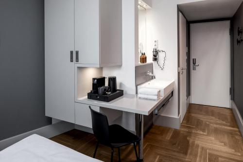 a bathroom with a desk and a sink at Hotel AMANO Rooms & Apartments in Berlin