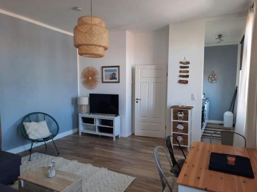 a living room with a table and a television at Apartment mit beach flair in Garz-Rügen