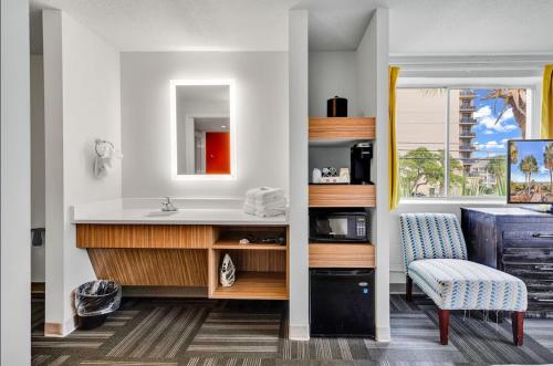 a bathroom with a sink and a chair at Holiday Shores Myrtle Beach in Myrtle Beach