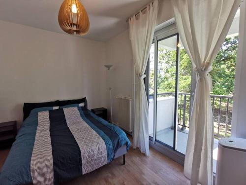 um quarto com uma cama e uma varanda em Cosy Apartment at Mérignac-centre em Mérignac