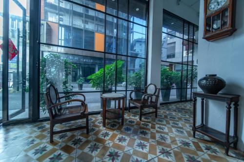 a room with chairs and a table and windows at Zhangjiajie Wangyi Inn in Zhangjiajie